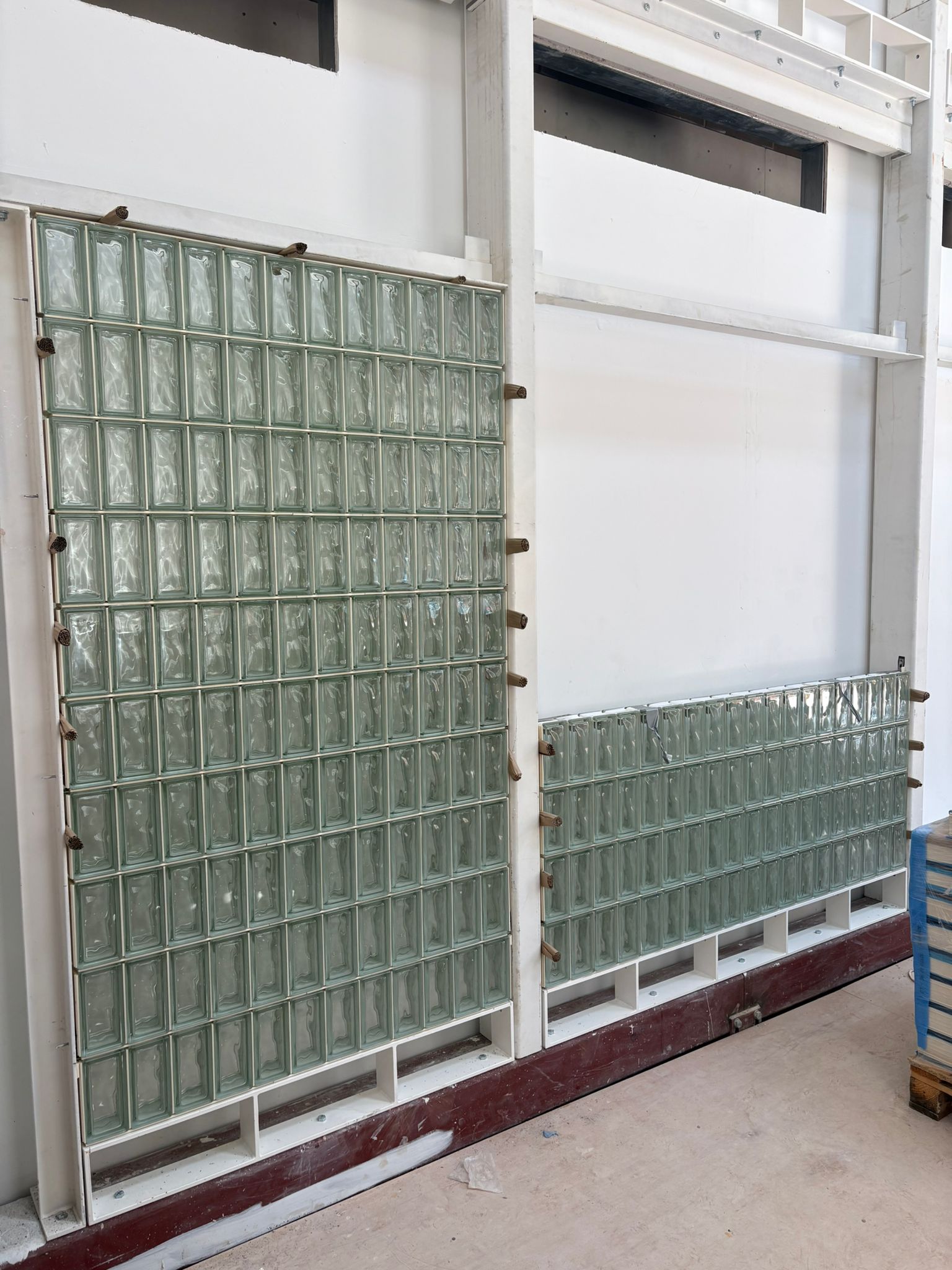 close up glass brick wall, steel framework, white grout joints